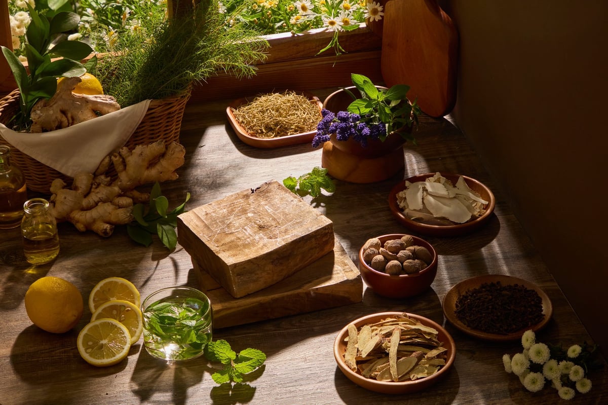 A close composition of herbs, roots, and wooden bowls arranged naturally. Wooden background and sunlight for herbal and eastern medicine branding